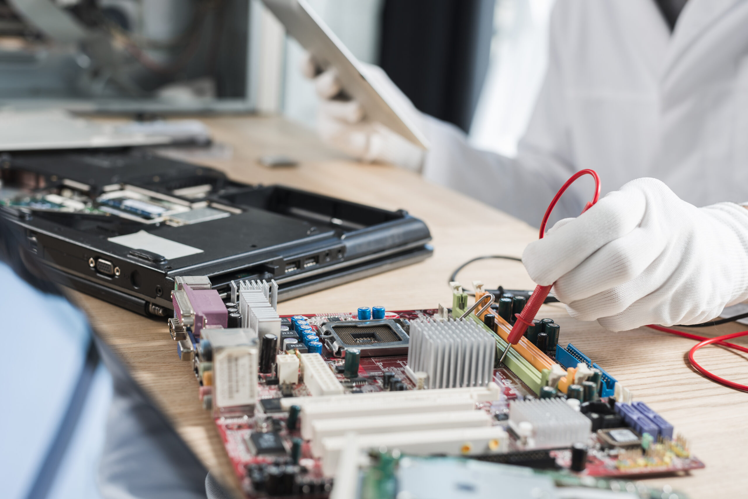 male-technician-examining-mother-board-with-digital-multimeter